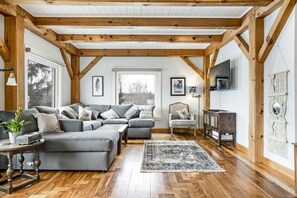 Sun-bathed living room with smart TV and Bluetooth sound system.