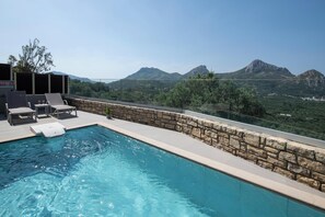 Pool terrace is equipped with two sun beds, sun umbrella and an outdoor shower