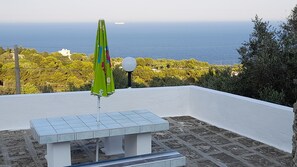 Terrazzo superiore vista mare con tavolo sedie e ombrellone e sdraio
