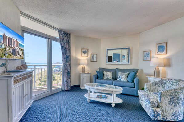Relax in the comfort of a large well-appointed living room with an ocean view.