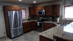 Remodeled kitchen with stainless appliances, new granite, and maple cabinetry.