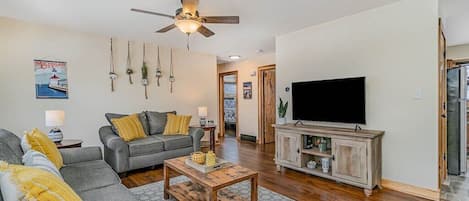 Living area with comfortable couches, fresh decor, and a smart TV.