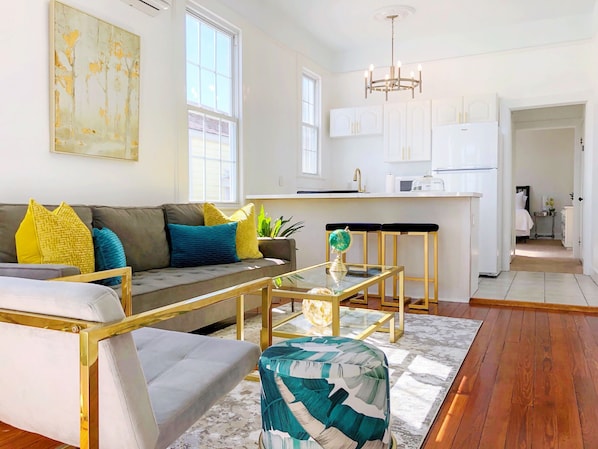 A fresh and spacious living room and kitchen full of natural light. 