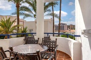 Covered balcony with comfortable seating, offering a private outdoor space to dine and relax.