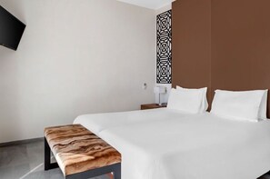 Sleek and minimalist bedroom with a chic headboard, offering a tranquil retreat for guests.