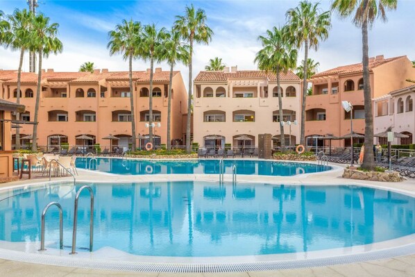 Lush resort-style pool surrounded by palm trees for an oasis-like escape.