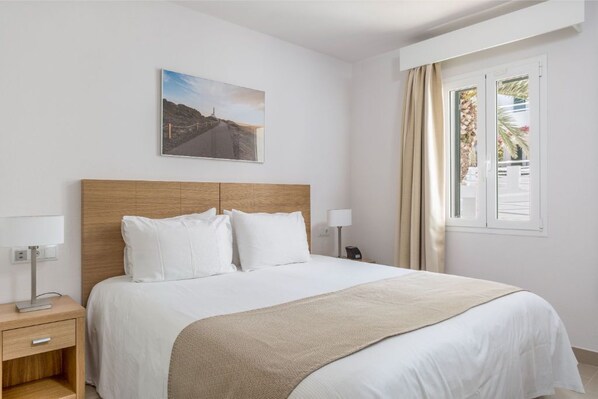 Bright bedroom with a comfortable bed and crisp white linens.