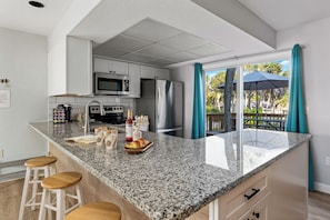 Newly remodeled, well stocked kitchen has all the room and wares you need.