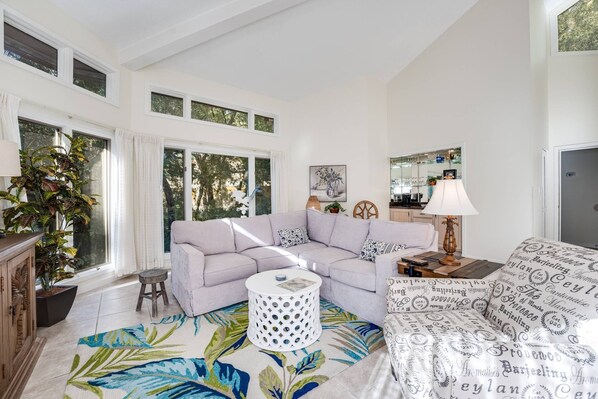 Living Room Retreat: Bright and airy space with tropical decor and abundant natural light!