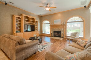 Comfortable living room with TV, fireplace, & large windows