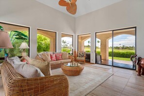 Tropical living room with 70" Smart TV, garden view and lanai access