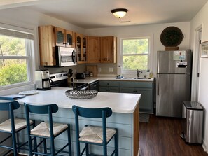 Fully equipped kitchen with large peninsula and 3 barstools