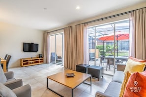 The living room offers direct access to the enclosed lanai w/outdoor dining