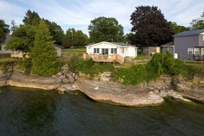 The house shoreline - stairs are brown and in middle down to rock ledges