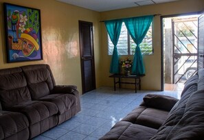 Main living room with sofa for your comfort, it has attached a half bathroom