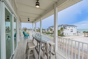 Spacious front patio, featuring a large table and plenty of seating. It's the perfect spot to sip your morning coffee, share a meal, or just relax and take in the beautiful beach views.