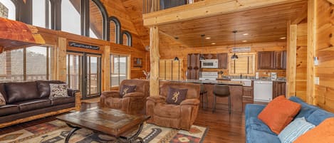 Open living room and kitchen with unique arched sky windows