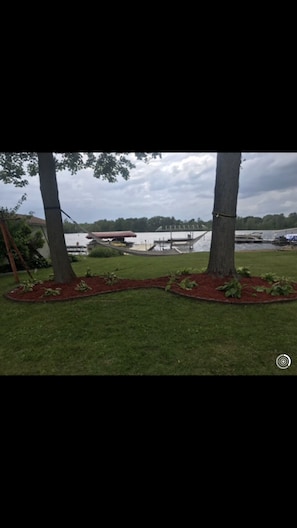 Back yard with sandy beach/swim area, and hammock.