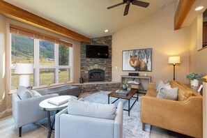 Living area with new wide plank luxury vinyl flooring, rug, leather sofa, chairs