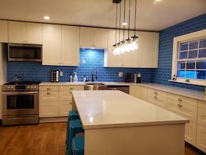 The new kitchen with island and blue subway tile