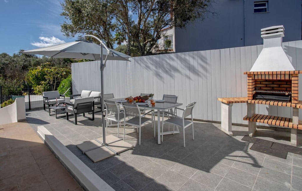 Terrace with garden furniture and a stone oven