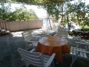 Large terrace with sea view, table-chairs and deck chairs