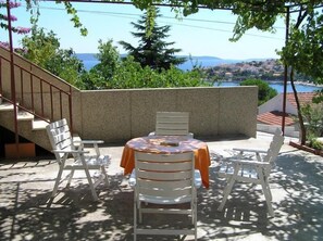 Large terrace with sea view, table-chairs and deck chairs