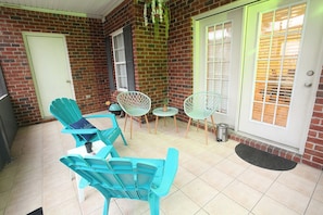 Back porch with pretty green outdoor furniture and cute tiny charcoal grill!
