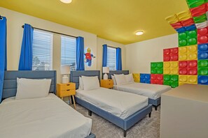 Wake up everyday in this cute and charming bedroom with 3 comfy beds, a large dresser, and a colorful puzzle-piece wall