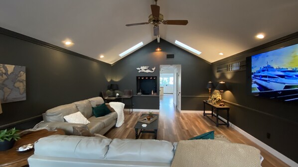 Awesome living room, 75” Samsung SmartTV, and bar area with separate fridge. 