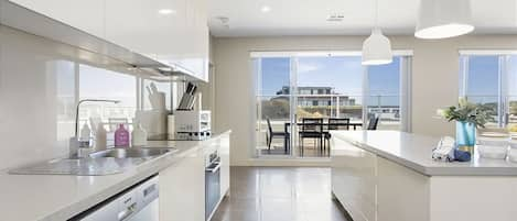 A contemporary kitchen leek stainless steel appliances and a chic breakfast bar.