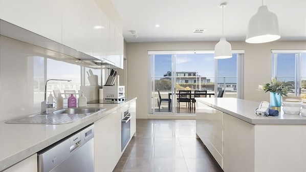 A contemporary kitchen leek stainless steel appliances and a chic breakfast bar.