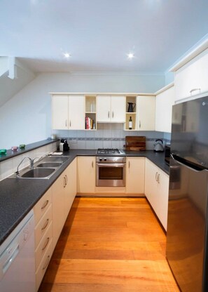 Cook, dine, or entertain with ease. The kitchen features quality appliances, including a gas cooktop, oven, microwave, full-size fridge, dishwasher, kettle, and toaster.