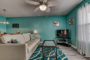 Living Area - The spacious living area offers a large sofa, end table with lamp, coffee table, and a television for entertainment in your down time.