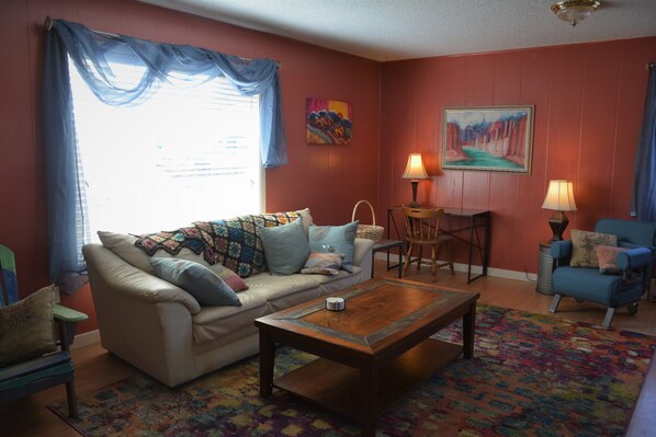 Living room with large window and comfortable large couch.
