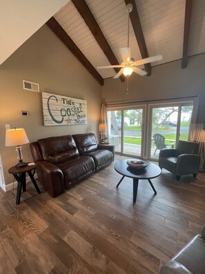 Vaulted ceilings with wood beams and shiplap accents. 