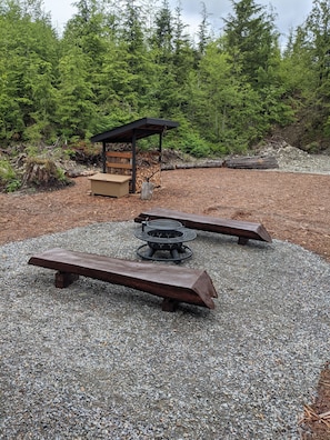 Fire pit with adjustable grill and hand hewn cedar log benches from property.