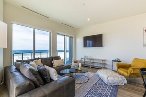 Living room with a luxurious leather couch, TV and views from every angle of the room.