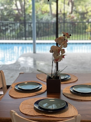 DIning table on the covered  back and screened pool lanai. 