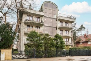 The apartment building's exterior with greenery surrounding it, providing a quiet, pleasant view.