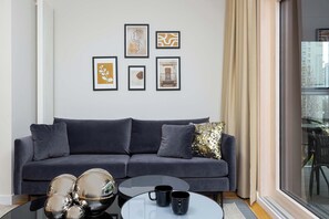 The elegant living room featuring a double sofa bed, perfect for relaxing or sleeping.