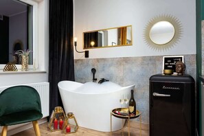 A bedroom with a bed, a small fridge, and warm lighting creating a relaxing atmosphere.