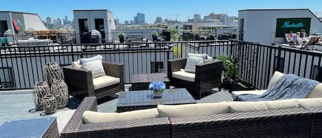 Plenty of room to spread out with sectional sofa, lounge chairs, sofa table, and a dining table with 4 stools on the private rooftop with Downtown Views