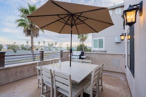 Equipped with a barbecue grill, ample seating, and a dining table, it provides an ideal setting for al fresco dining and relaxation with scenic ocean views in the background. Outdoor living is steps from the kitchen area.