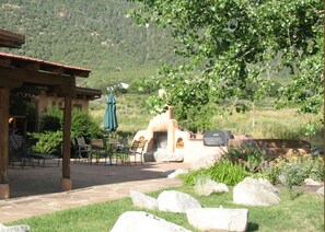 Favorite gathering spot expanded to show jumbo hot tub (right side with lid on) grill and fireplace  to left and glorious mountain views