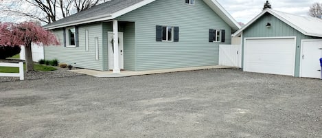 View of house with large driveway, single car garage 