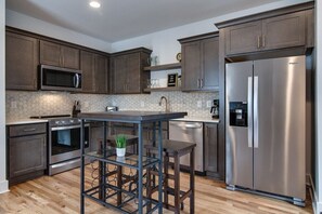 The thoughtfully designed pub table in the kitchen is a space-saving gem, providing plenty of room for dining and gathering with ease.