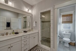 The primary bathroom suite features a walk-in shower, double vanity, and abundant natural light.