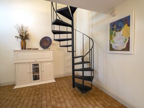 Enter this bright villa with spiral staircase, beautiful art, and welcoming decor.