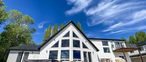 Modern mountain retreat with expansive windows, hot tub, and sunny deck—perfect for relaxing or entertaining.